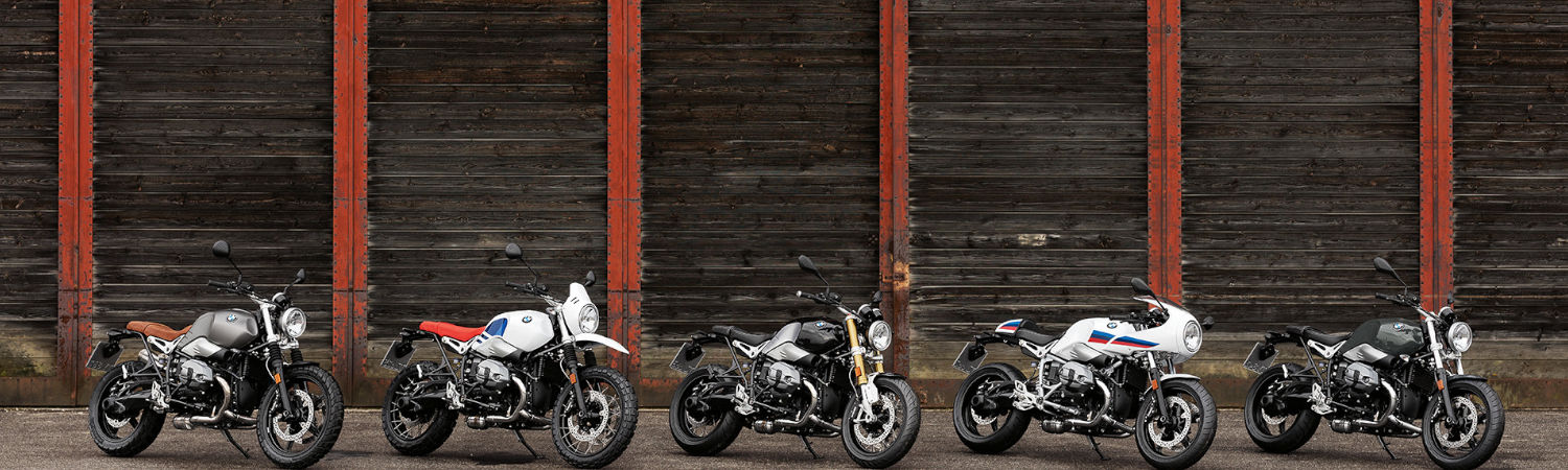 Five 2020 BMW motorcycles parked in front of a wooden building